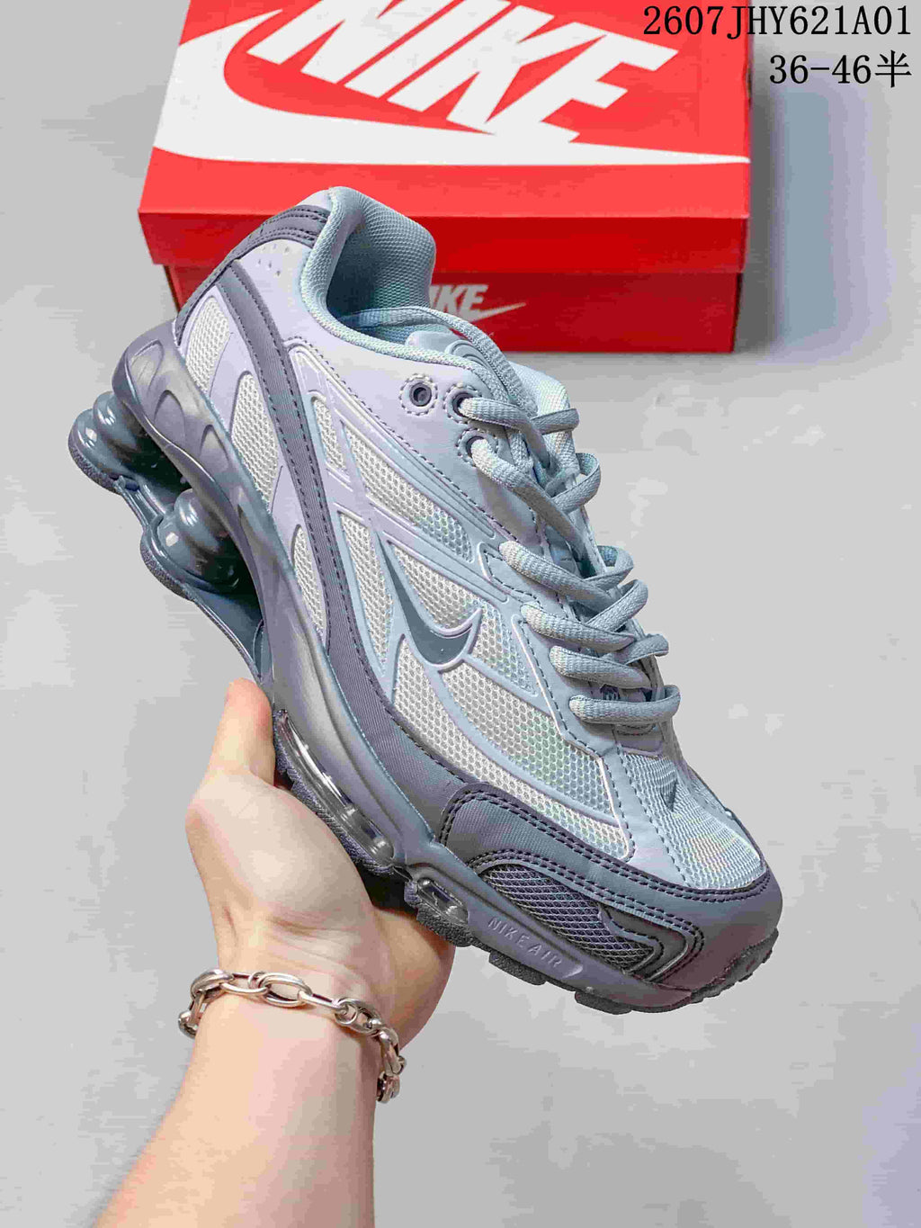 Angled side view of the silver and gray sneaker with its column-shaped heel