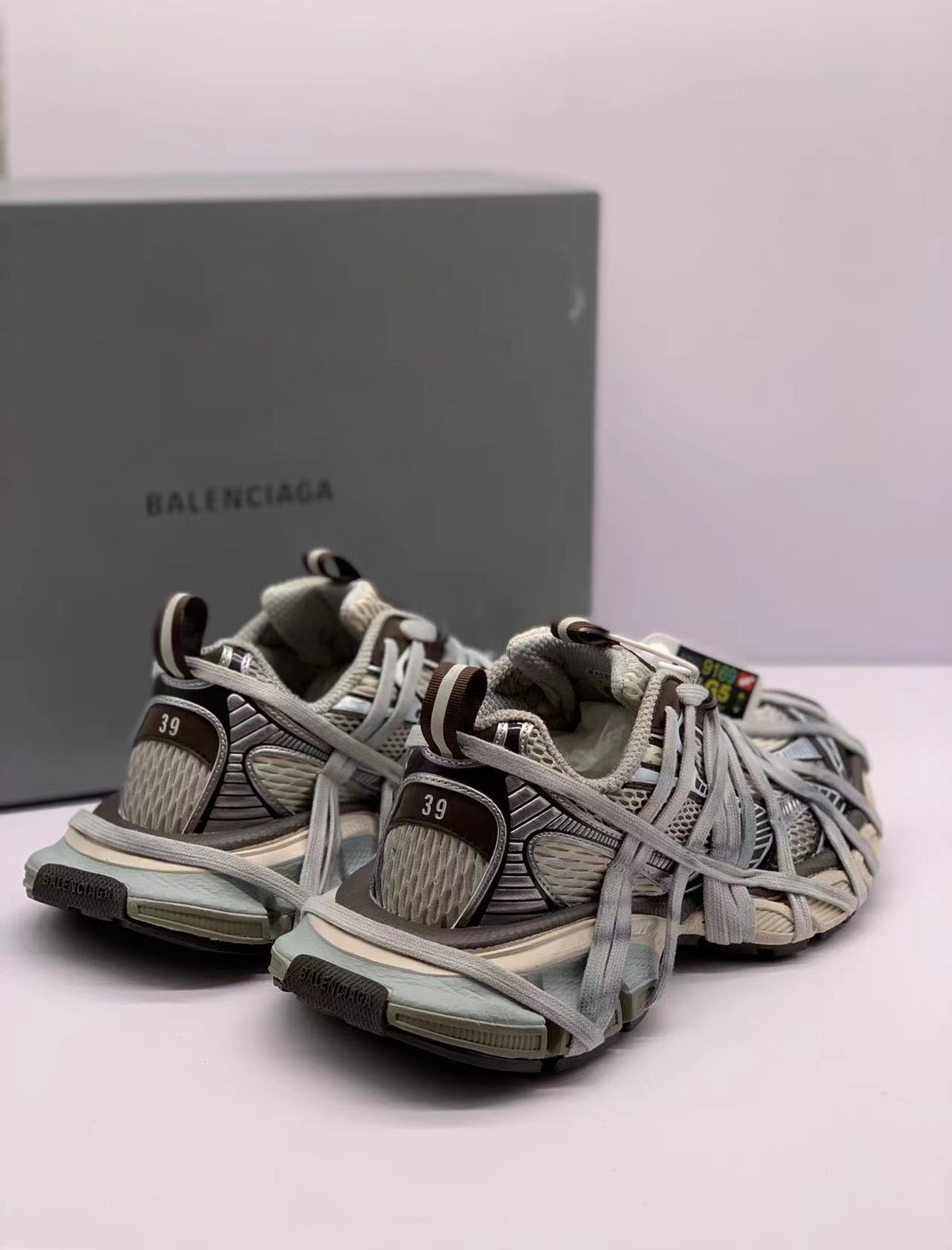 Three-quarter rear view highlighting the heel panels, pull tabs, layered laces, and textured outsole edges.