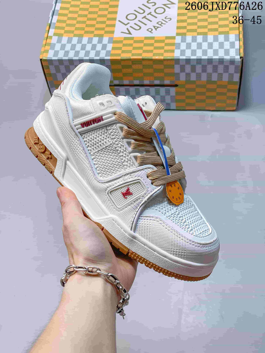 White low-top sneaker with tan laces and gum-colored outsole details