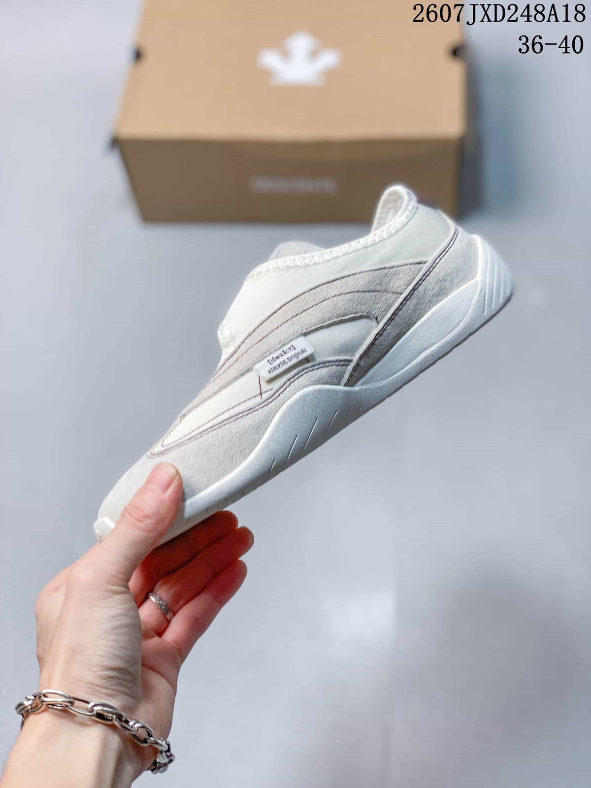 Side view of the white low-top sneaker showing layered panels, stitching, and the low-profile sole; the image shows the code 2607JXD248A18 and size range 36–40.