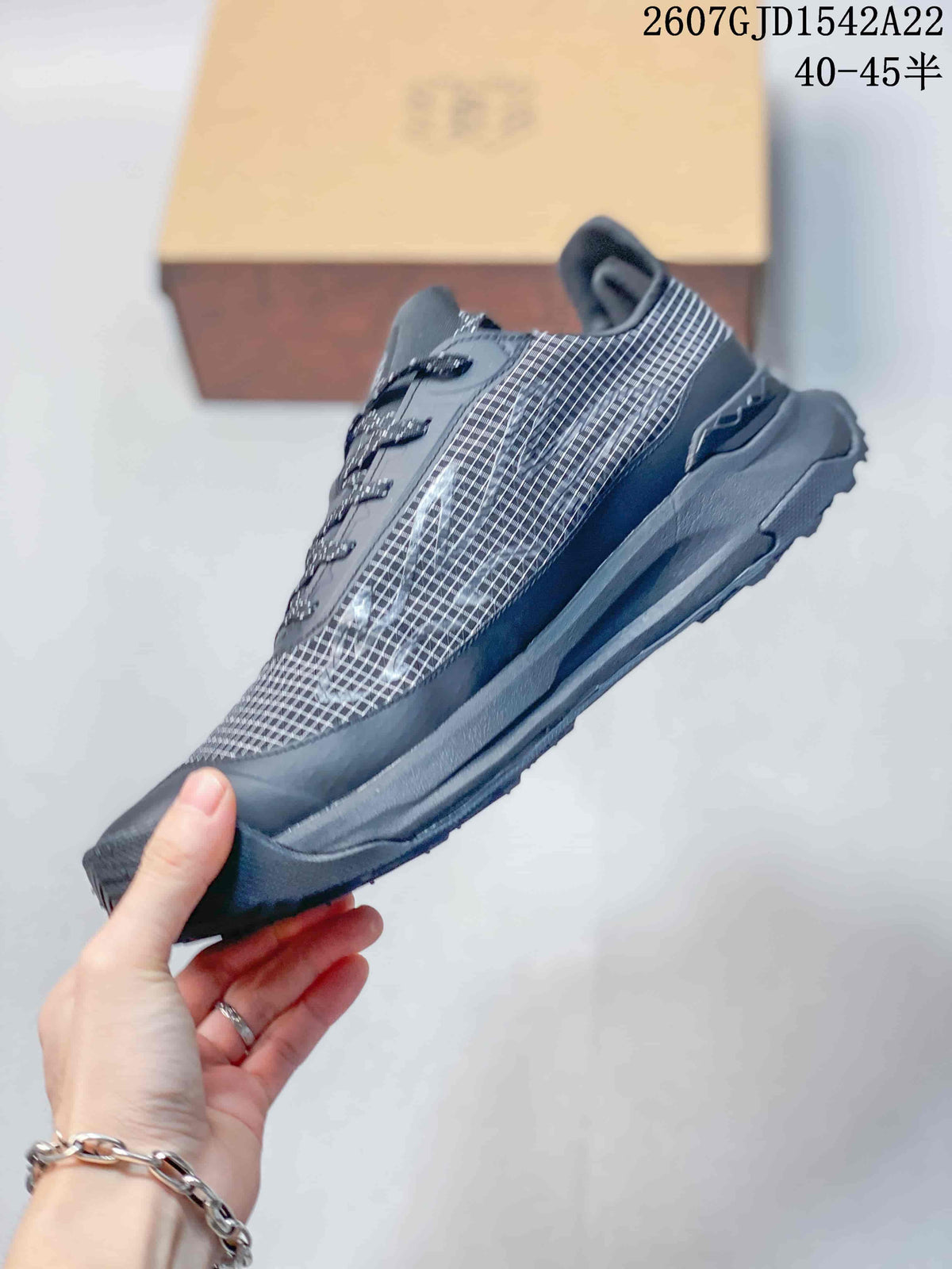 Side view highlighting the dark grid-patterned upper, lace system, reinforced toe and thick outsole.