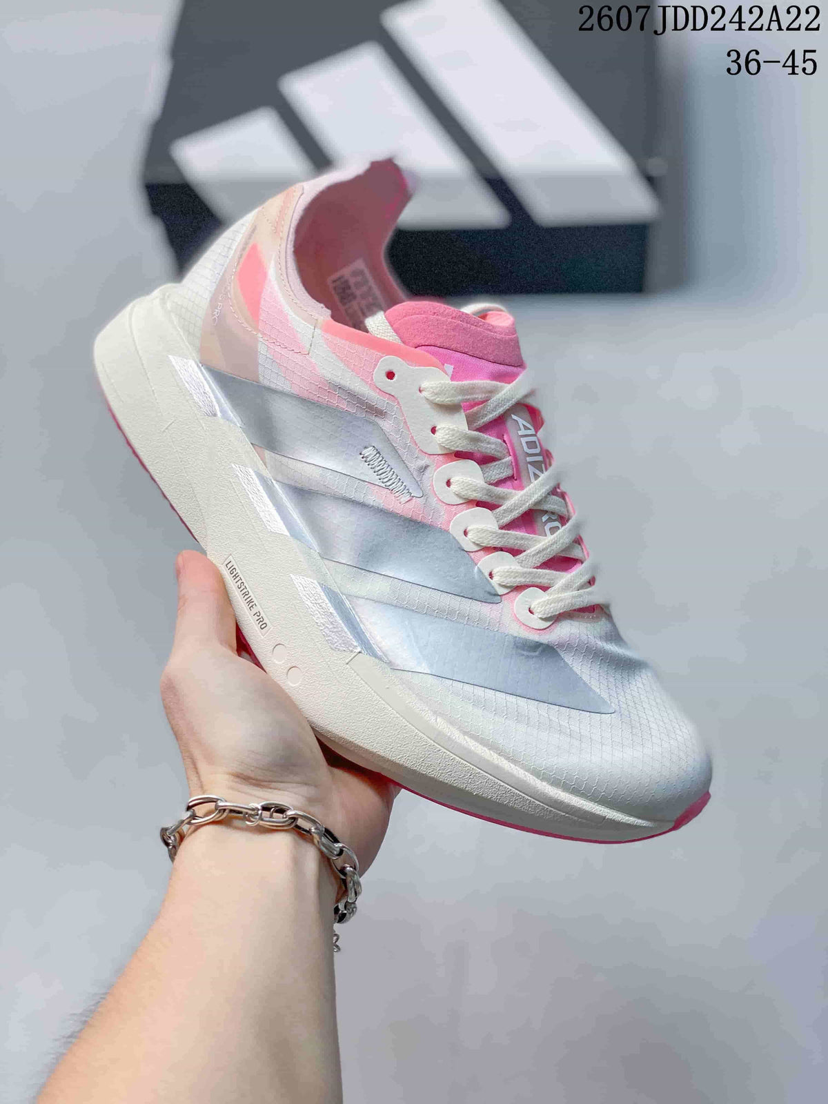White and pale pink Y-3 Adios Pro 4 sneaker with pink accents and a pink outsole edge; image text shows JDD242A22 and sizes 36–45.