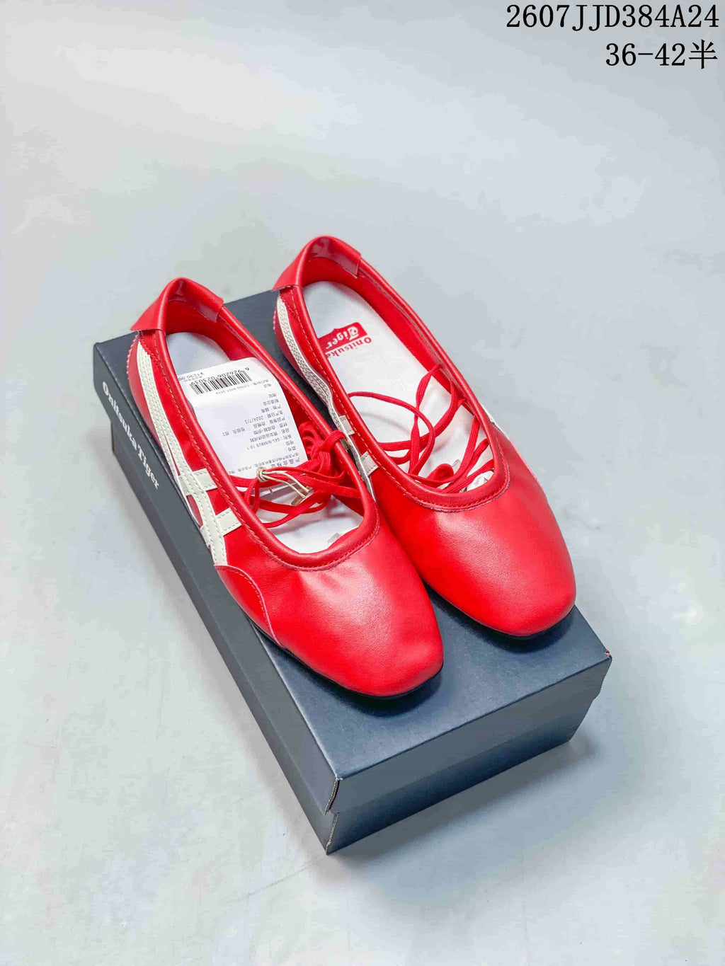 Pair of red Onitsuka Tiger shoes with white side stripes displayed on a black shoebox; overlay text identifies style 2607JJD384A24 and sizes 36–42 with half sizes.