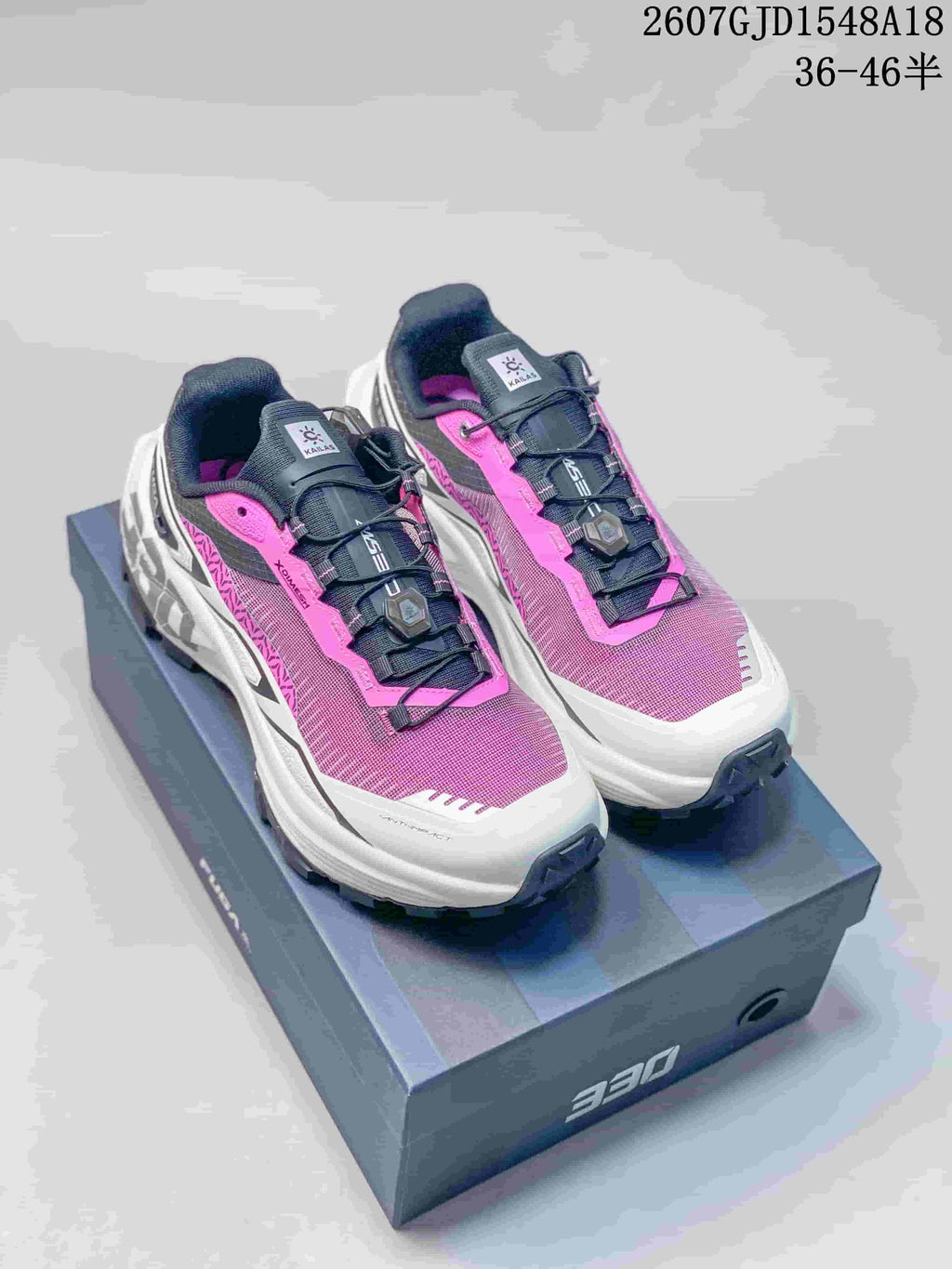 Pair of pink, white and black Kailas FUGA DU 2 trail running shoes shown on a shoebox.