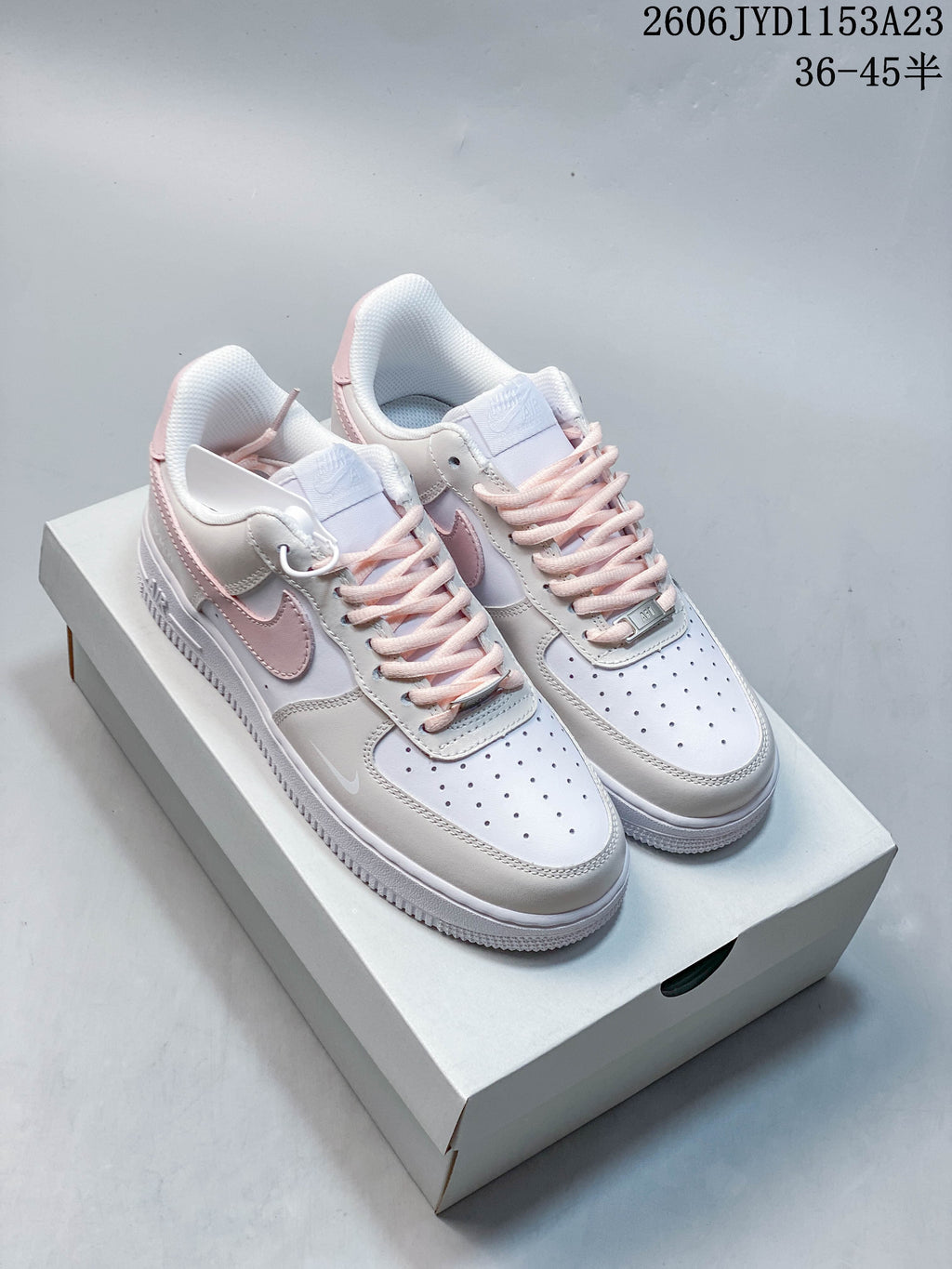 Pair of white and pale grey Nike Air Force 1 style sneakers with blush-pink accents on a box; image overlay shows 36–45.5.