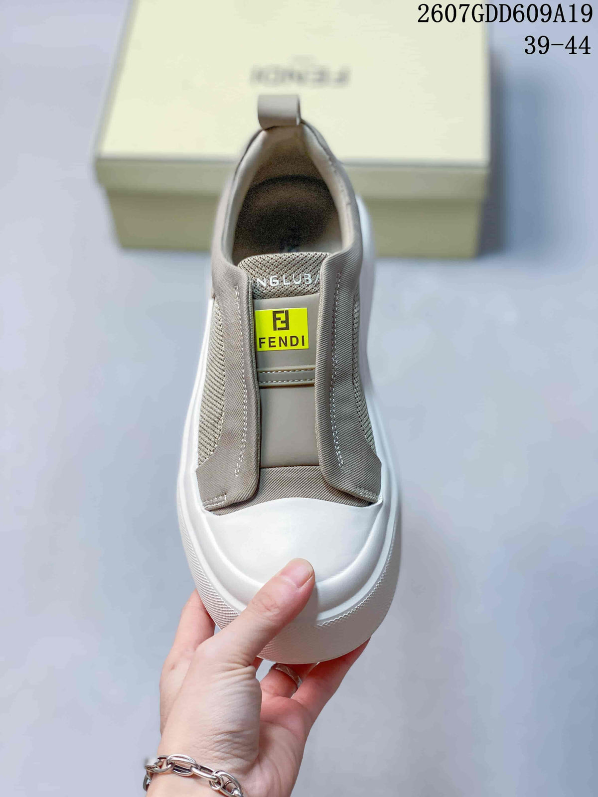 Top view of the sneaker showing the elasticated opening, tongue label, and white rounded toe.