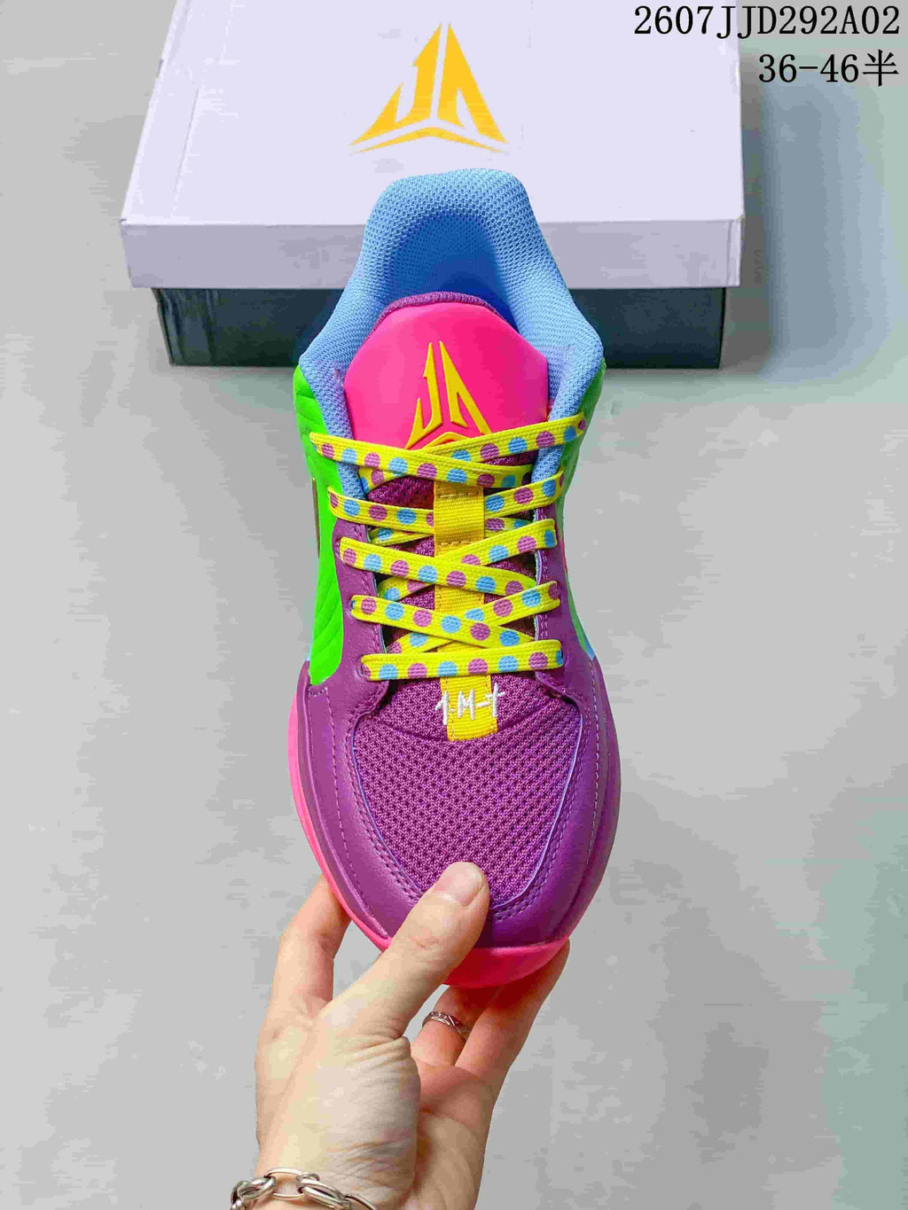Top view of the basketball shoe showing the purple toe area, padded tongue and patterned yellow laces.