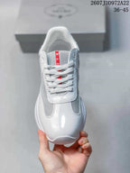 Top view of the white lace-up sneaker showing the rounded toe, gray mesh-style sections, and red tongue label.