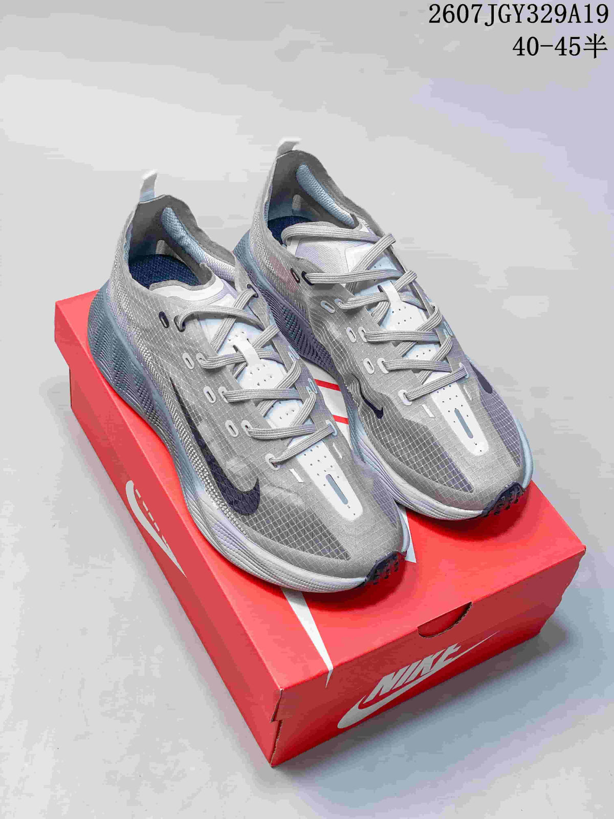Pair of gray Nike Ava X Rover low-top sneakers displayed on a red Nike shoebox, with the size range and style reference visible above.