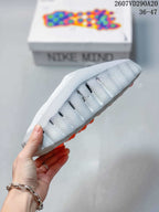 Side and outsole view showing the perforated light gray upper, sculpted sole, and orange outsole elements.