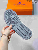 Close-up of the gray patterned outsole on a sneaker, with an orange shoe box in the background.