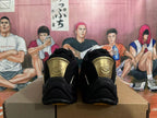 Rear view of black basketball shoes with gold-tone heel details.