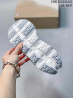 Outsole view showing the segmented white and gray tread pattern of the sneakers.