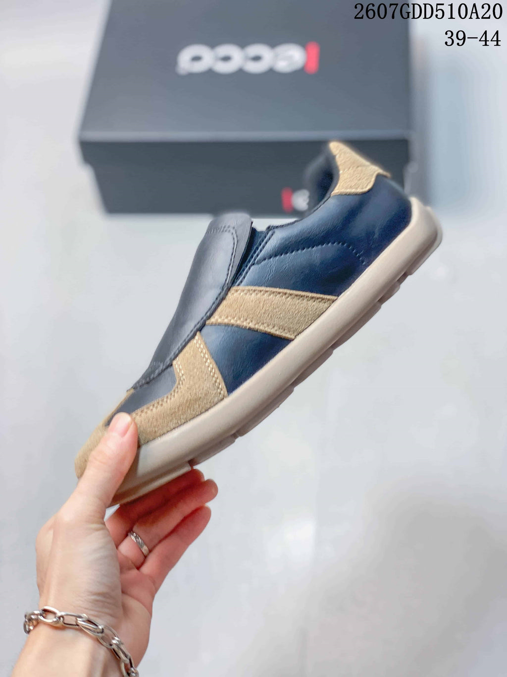 Side view of a navy and tan ECCO sneaker showing the layered upper panels and low-profile sole.