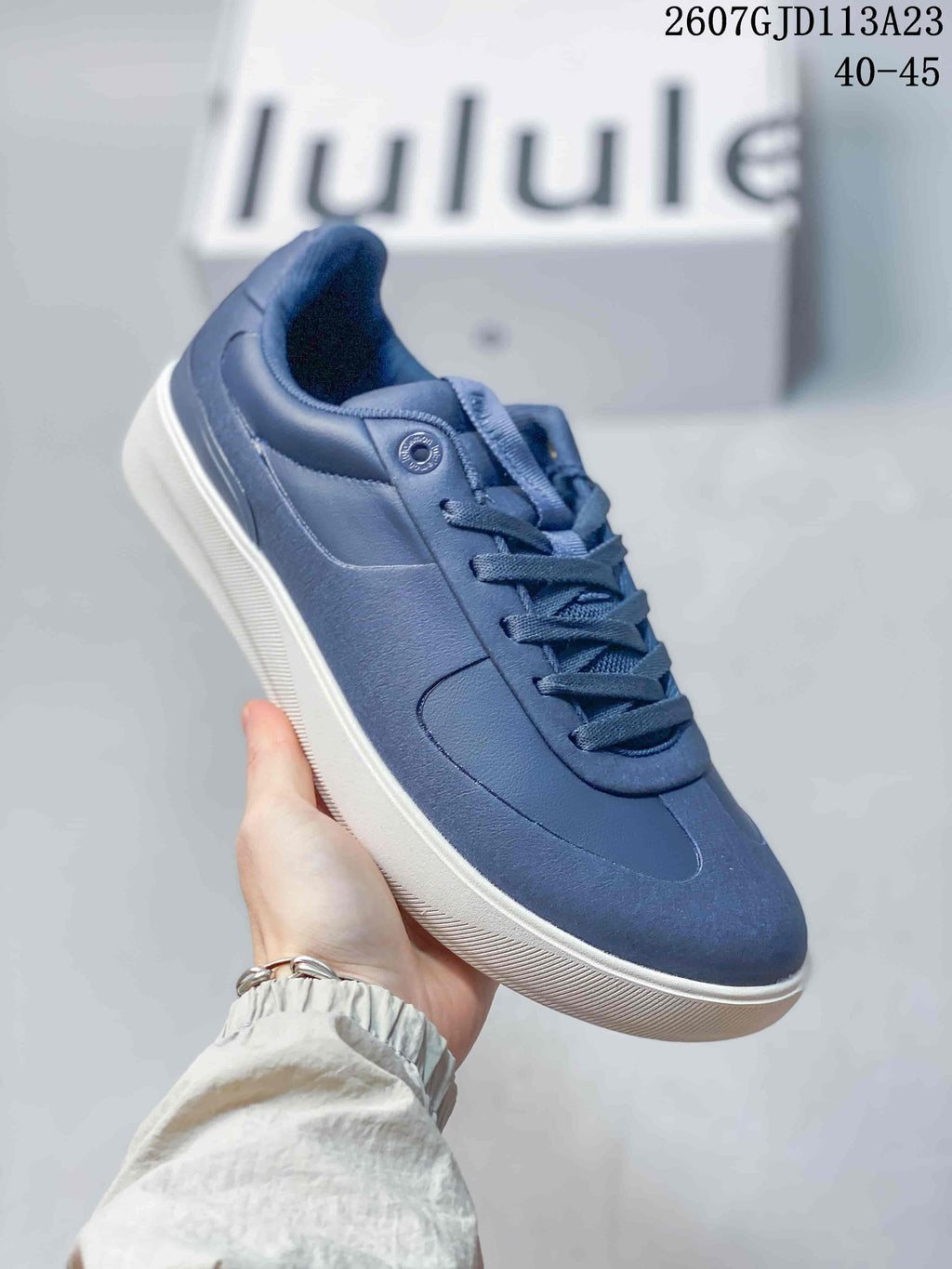 Side view of a navy lululemon Cityverse sneaker with tonal panels, padded collar, and white rubber outsole; image text shows style code 2607GJD113A23 and size range 40–45.