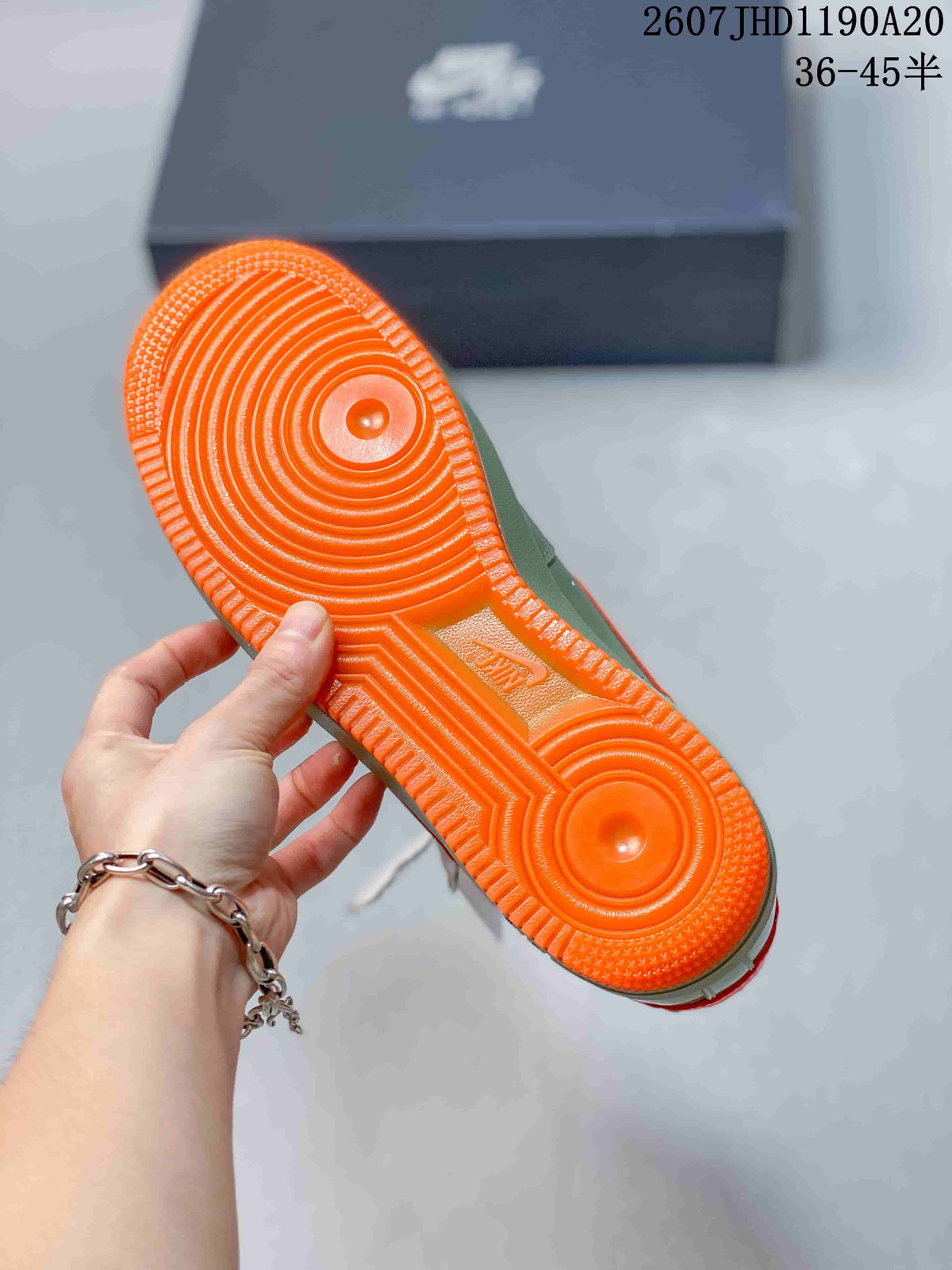 Close-up of the bright orange textured outsole with circular traction patterns.