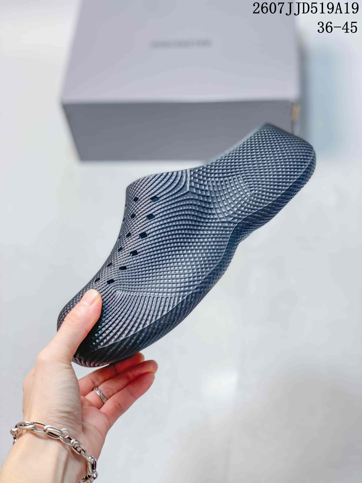 Side profile of a gray slip-on clog showing the raised sole and molded one-piece shape.