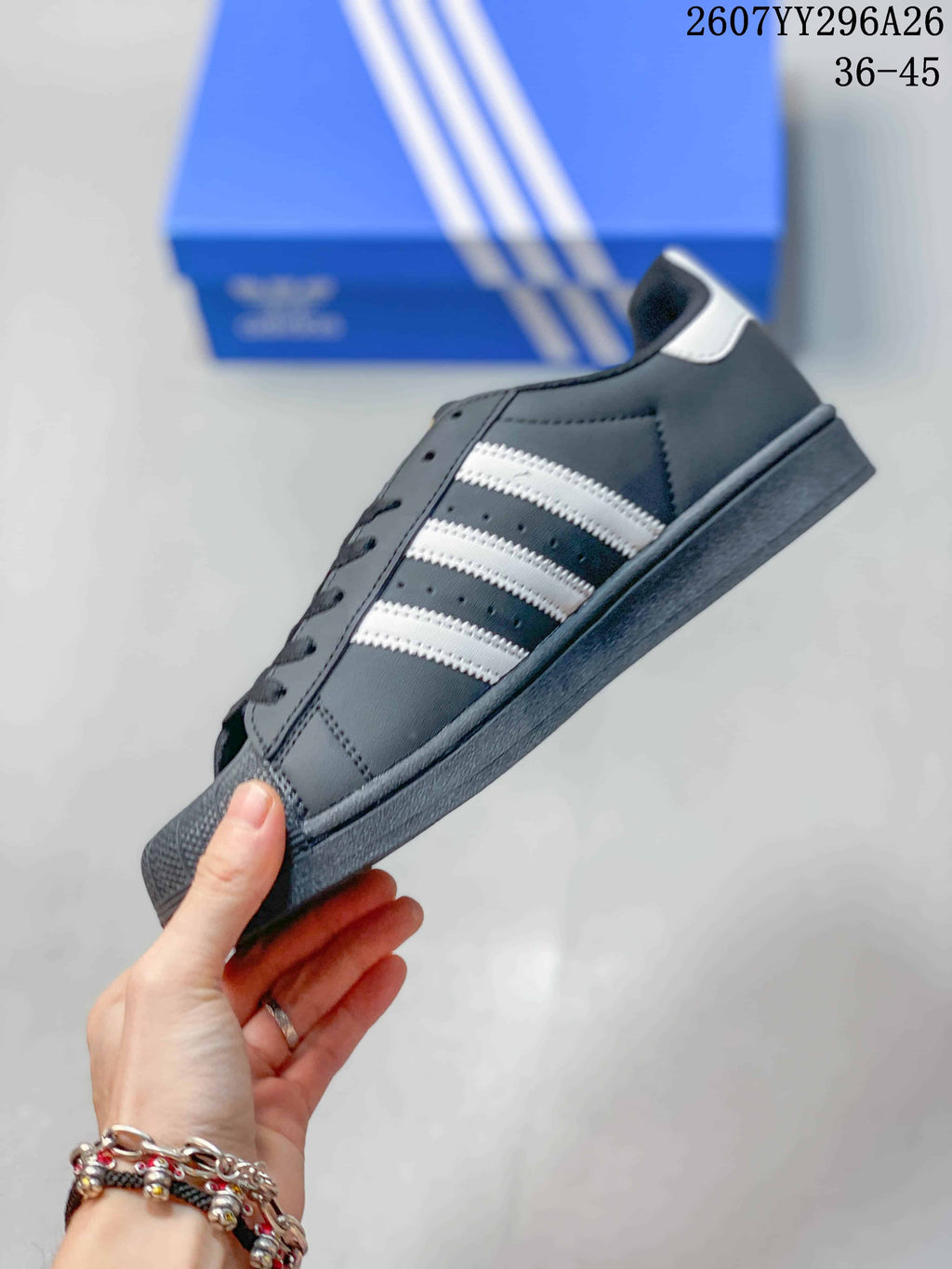 Side view of the black sneaker showing white stripes, perforated side panels, lace eyelets, and a dark sole.