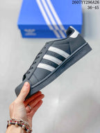 Side view of the black sneaker showing white stripes, perforated side panels, lace eyelets, and a dark sole.