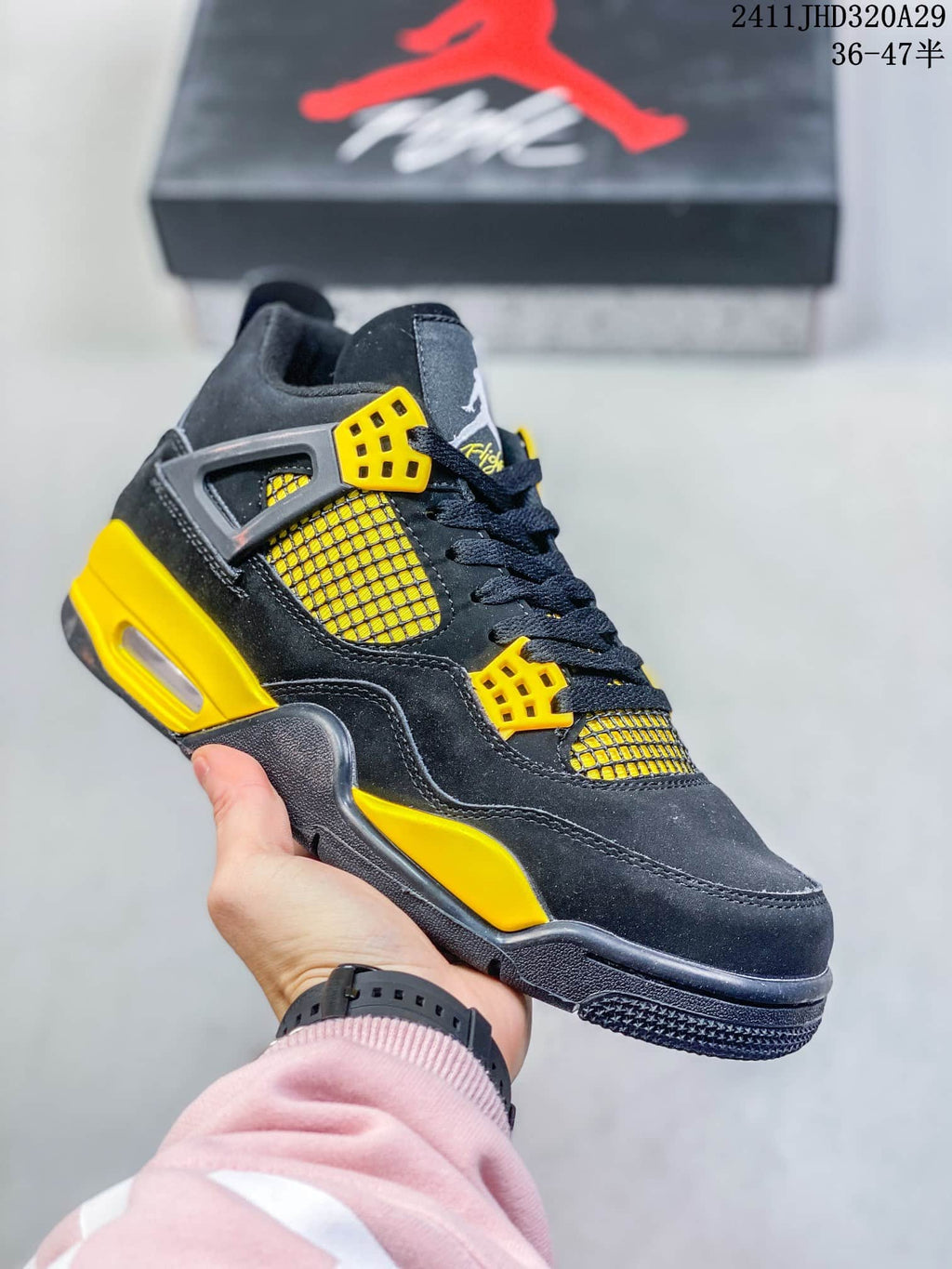Close-up of a black high-top sneaker with yellow eyelets, yellow side mesh, and yellow midsole accents.