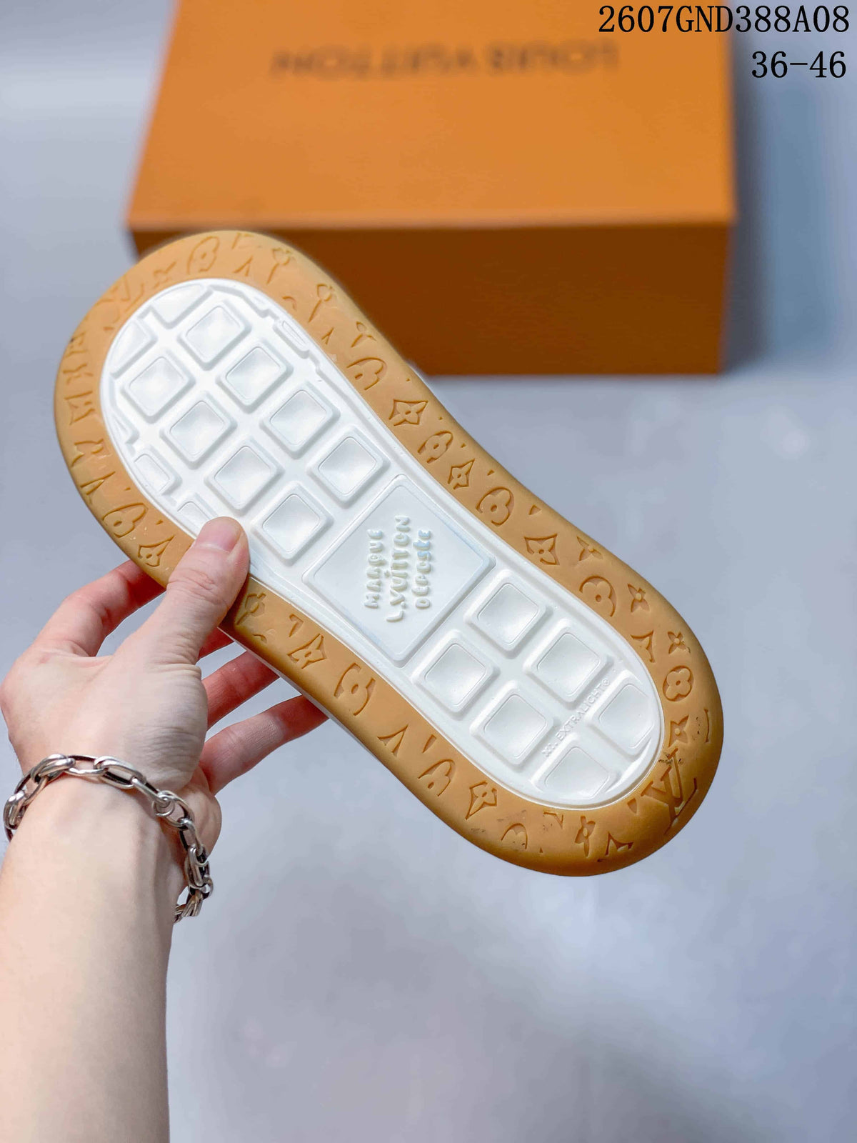 Outsole view showing the white tread center and gum-colored perimeter with embossed pattern details.