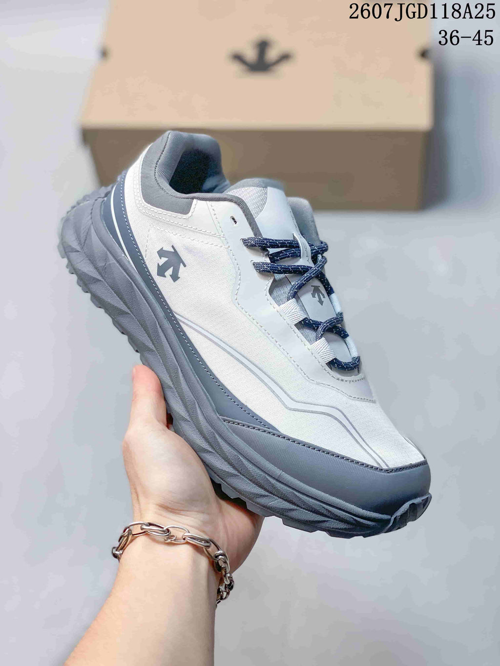 Angled side view of the white and gray Descente hiking sneaker with lugged sole