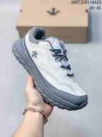 Angled side view of the white and gray Descente hiking sneaker with lugged sole