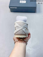 Rear view of the white and grey low-top sneaker showing the heel construction and cream-colored outsole.