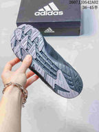 Close-up of the patterned outsole on a charcoal gray Adidas sneaker