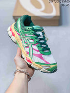 Angled side view highlighting the green and pink upper, layered overlays, cream midsole and dark tread.