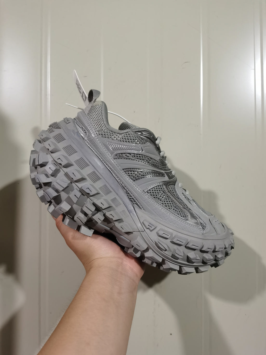 Angled front view of the grey Balenciaga Defender sneaker highlighting the mesh panels, overlays and textured outsole.