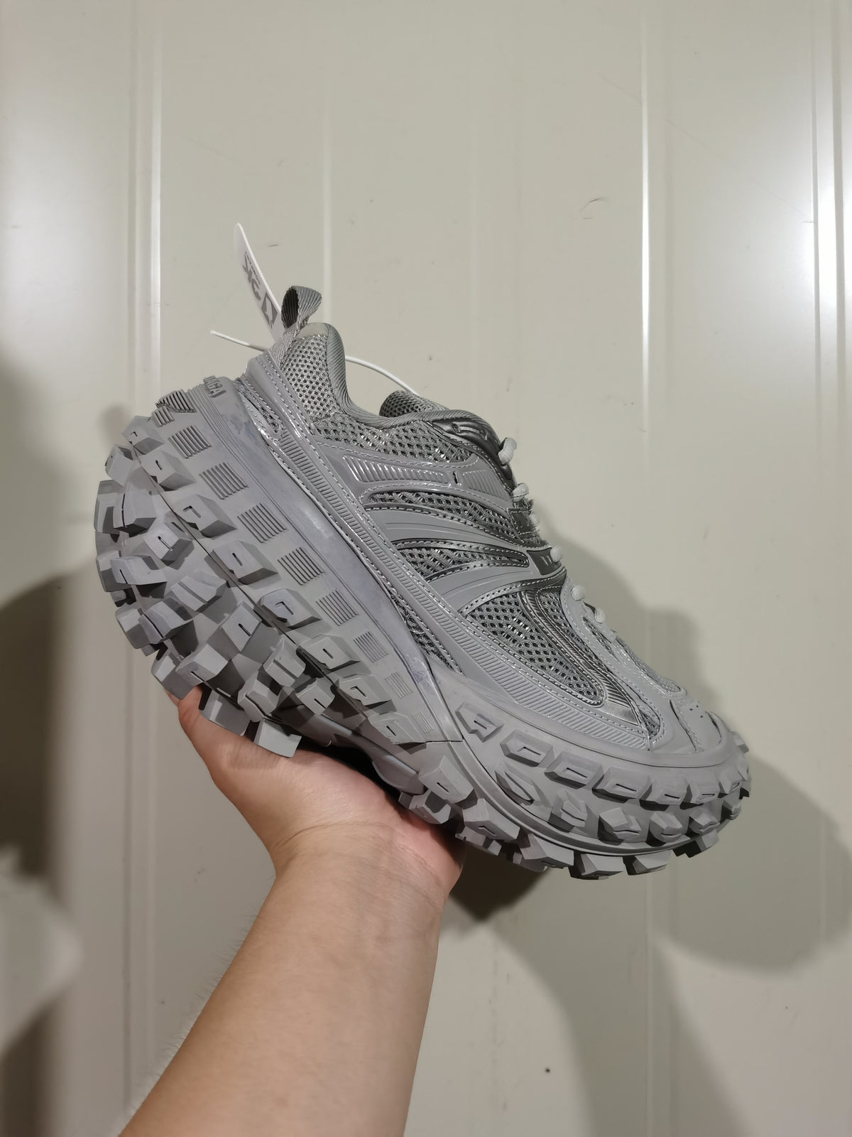 Angled front view of the grey Balenciaga Defender sneaker highlighting the mesh panels, overlays and textured outsole.