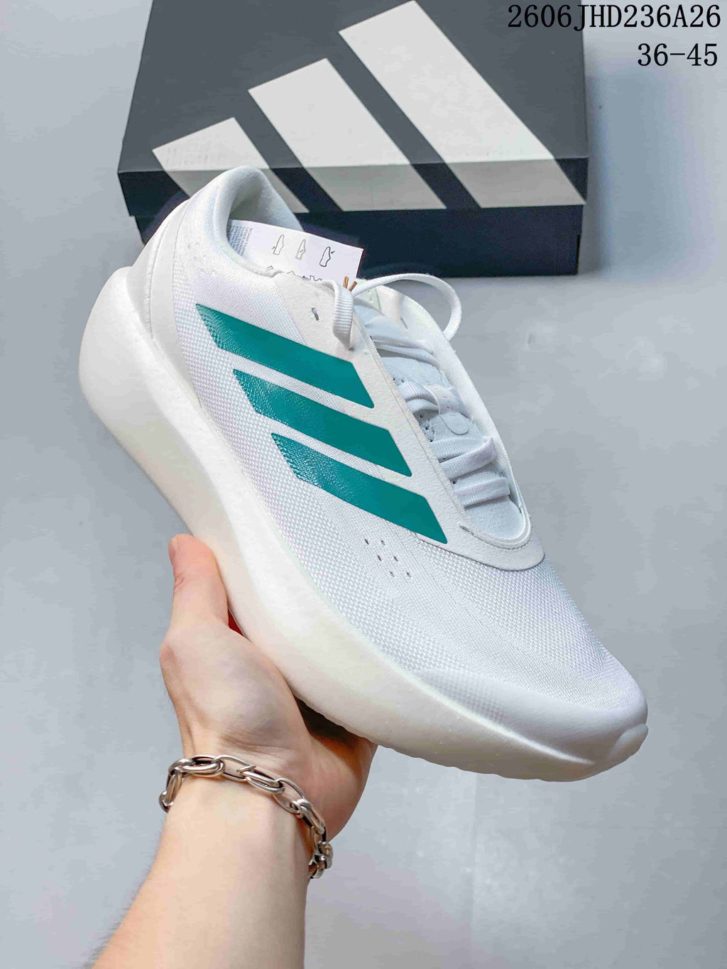 Angled side view of a white ZenBoost shoe with green stripes and a thick white sole.