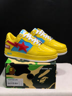 Pair of yellow BAPE low-top sneakers with blue panels, red star graphics, white laces, and a product box; the box label shows EU 41 and CM 26.