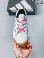 Top view showing the white toe box, wide tongue, pink laces and pale blue side details.