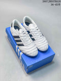 Pair of white and black adidas low-top sneakers displayed on a blue adidas shoebox.