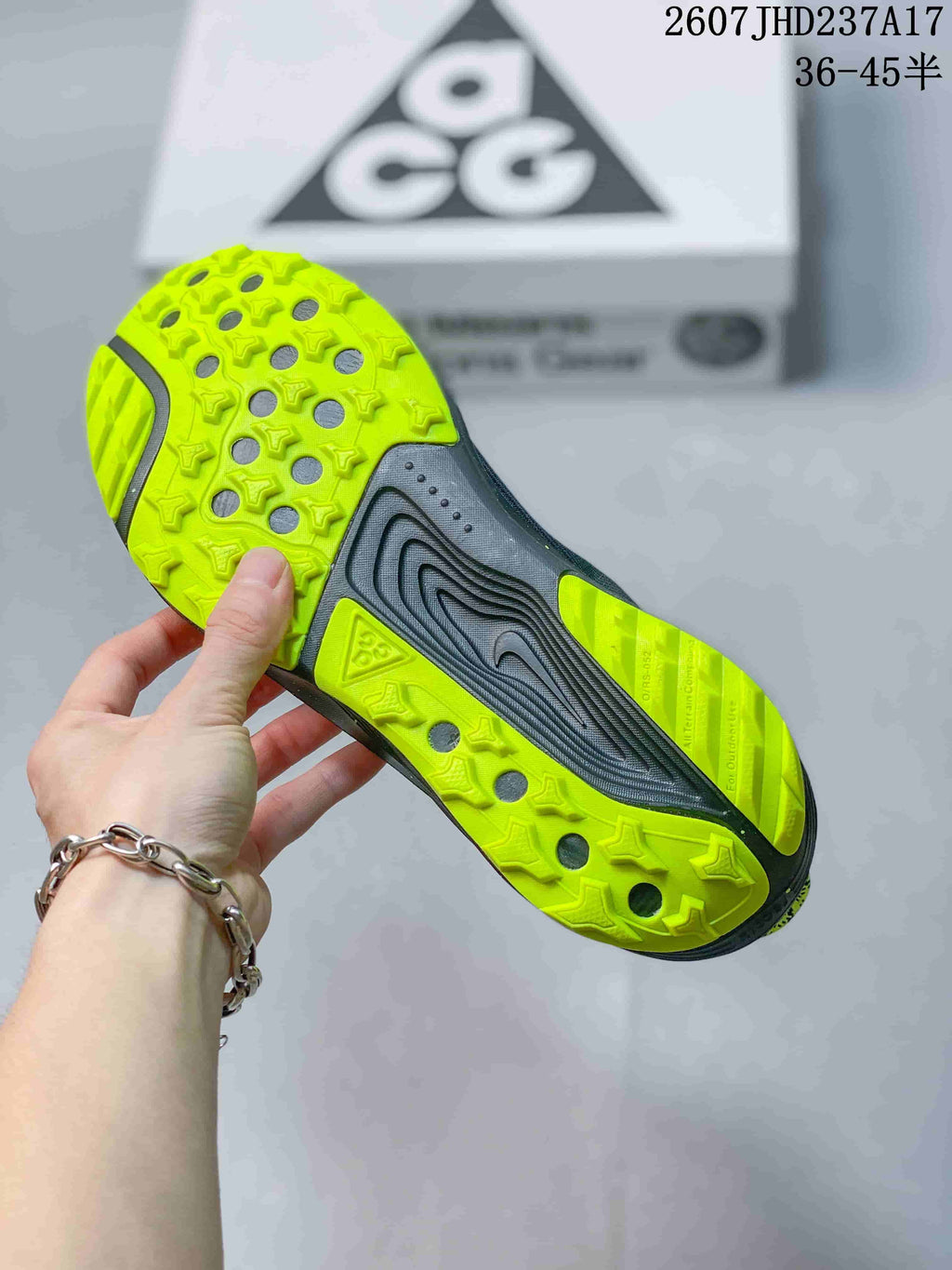 Close view of the lime trail outsole showing its patterned tread and circular openings.