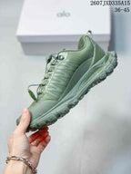 Side profile of the green low-top sneaker showing the layered upper panels, lace hardware, midsole, and lugged outsole.