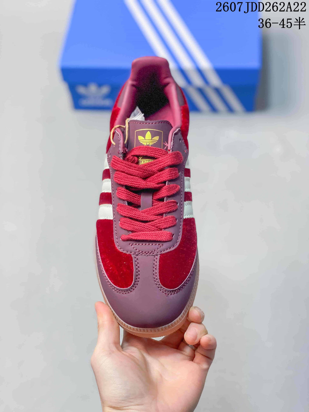 Top-down view of the burgundy sneaker with red laces and adidas tongue branding.