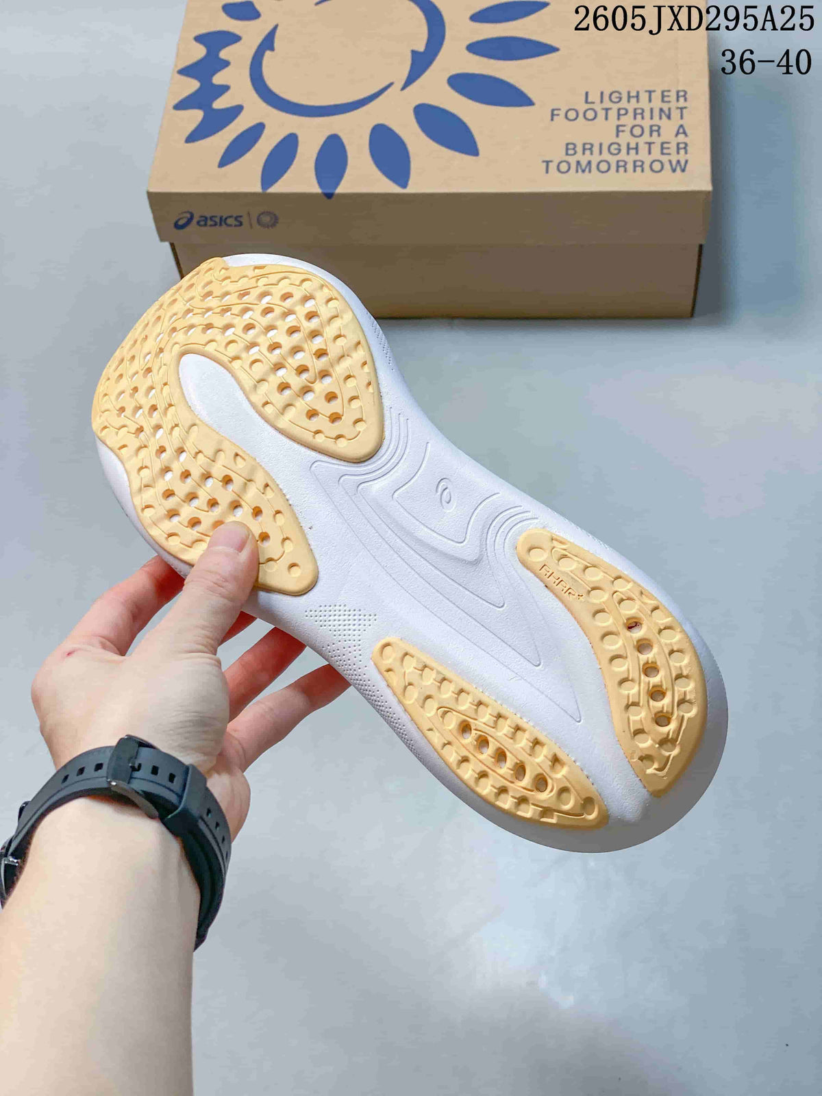 Underside of the shoe showing a white outsole with pale yellow traction sections