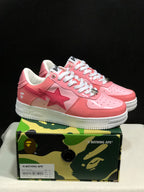 Pink and white BAPE Sta sneakers displayed on a camouflage BAPE shoe box; the box label shows EU 41 and CM 26.