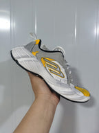 Gray, white, and yellow Skechers sneaker shown from a raised three-quarter side angle.