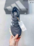 Top view of the lace-up sneaker showing the dark upper, Adidas tongue mark and attached product tag.