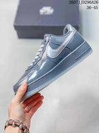 Side view of a grey low-top sneaker showing the contrasting Swoosh, stitching, perforations and rubber outsole; image text shows 2607JJD296A26 and 36–45.