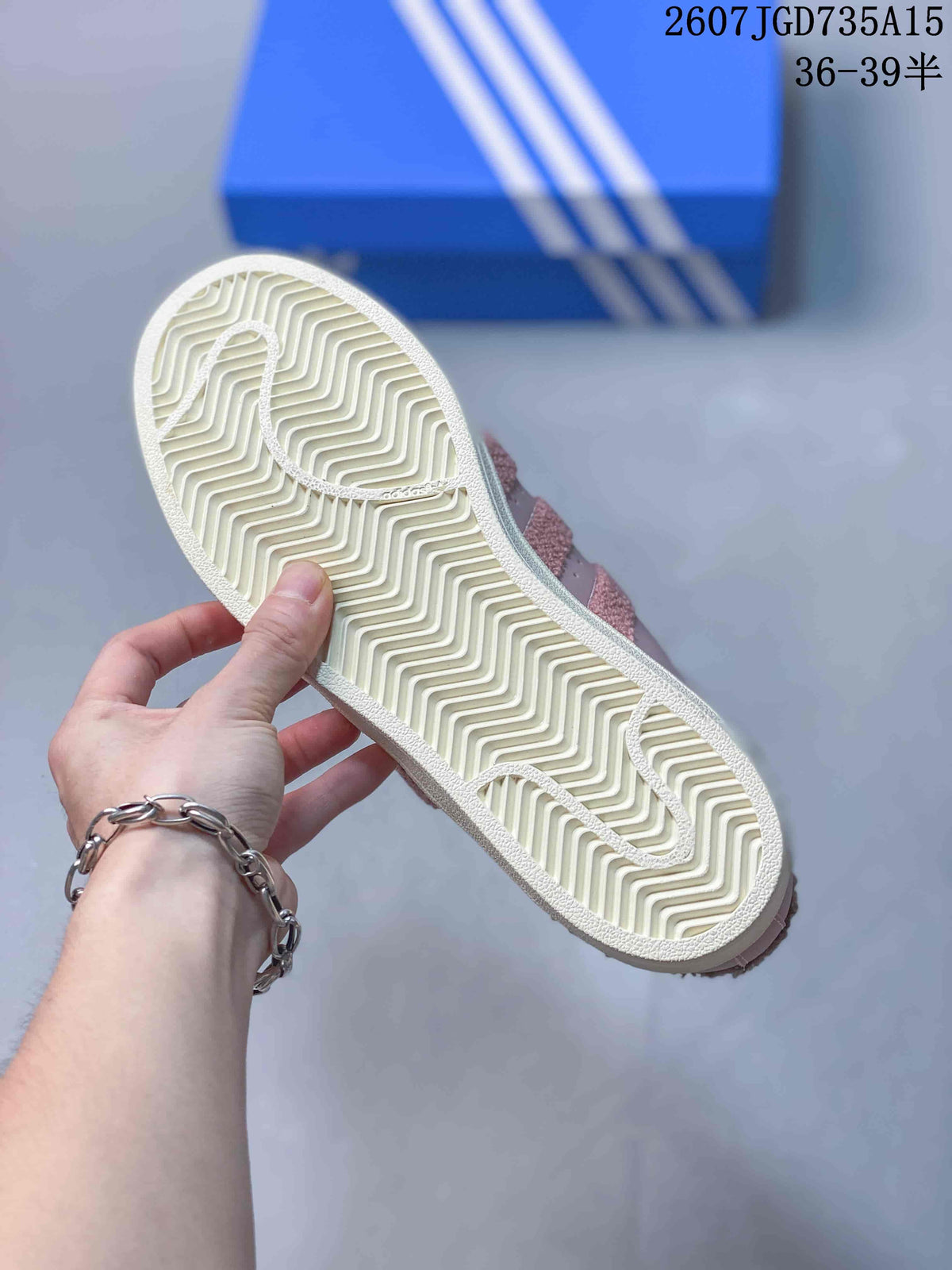 Close view of the cream rubber outsole with a zigzag tread pattern on a pink sneaker.