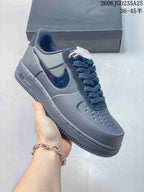 Angled side view of the dark Nike Air Force 1 sneaker showing the glossy Swoosh, perforated toe box, and Air-marked sole.