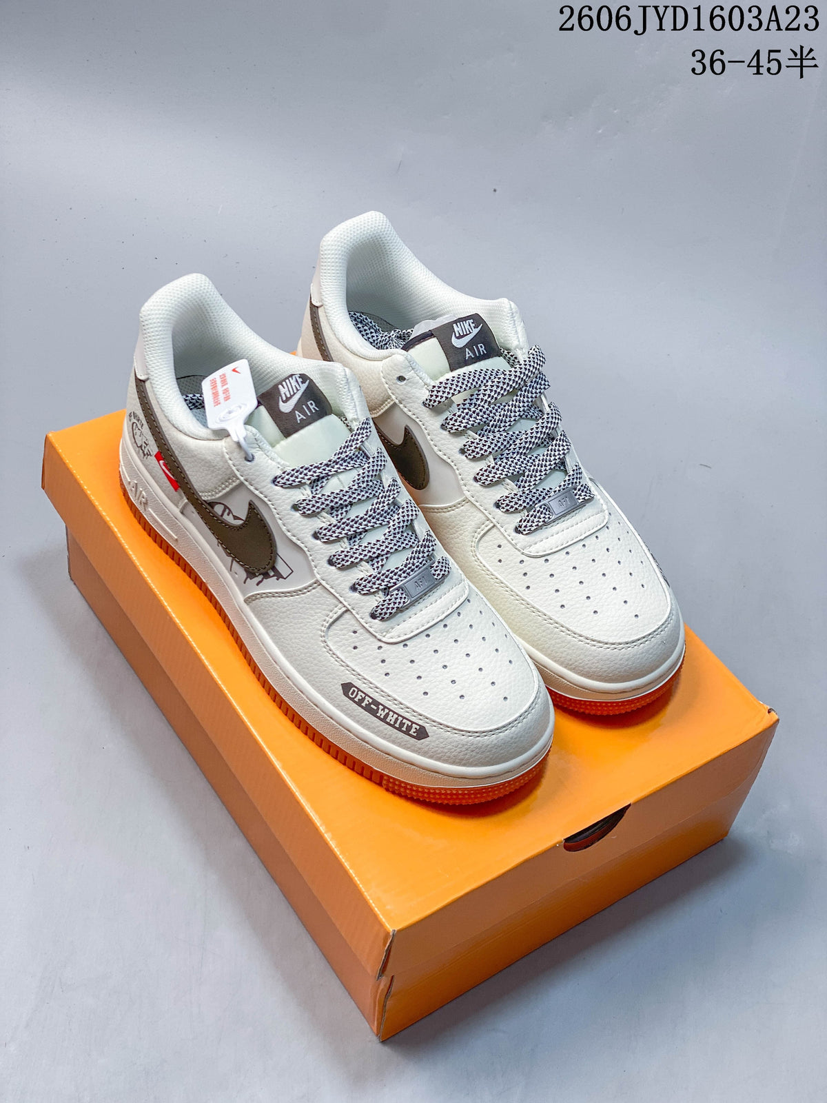 Pair of white low-top sneakers with gray-brown accents, patterned laces, printed graphics, and gum-orange outsoles