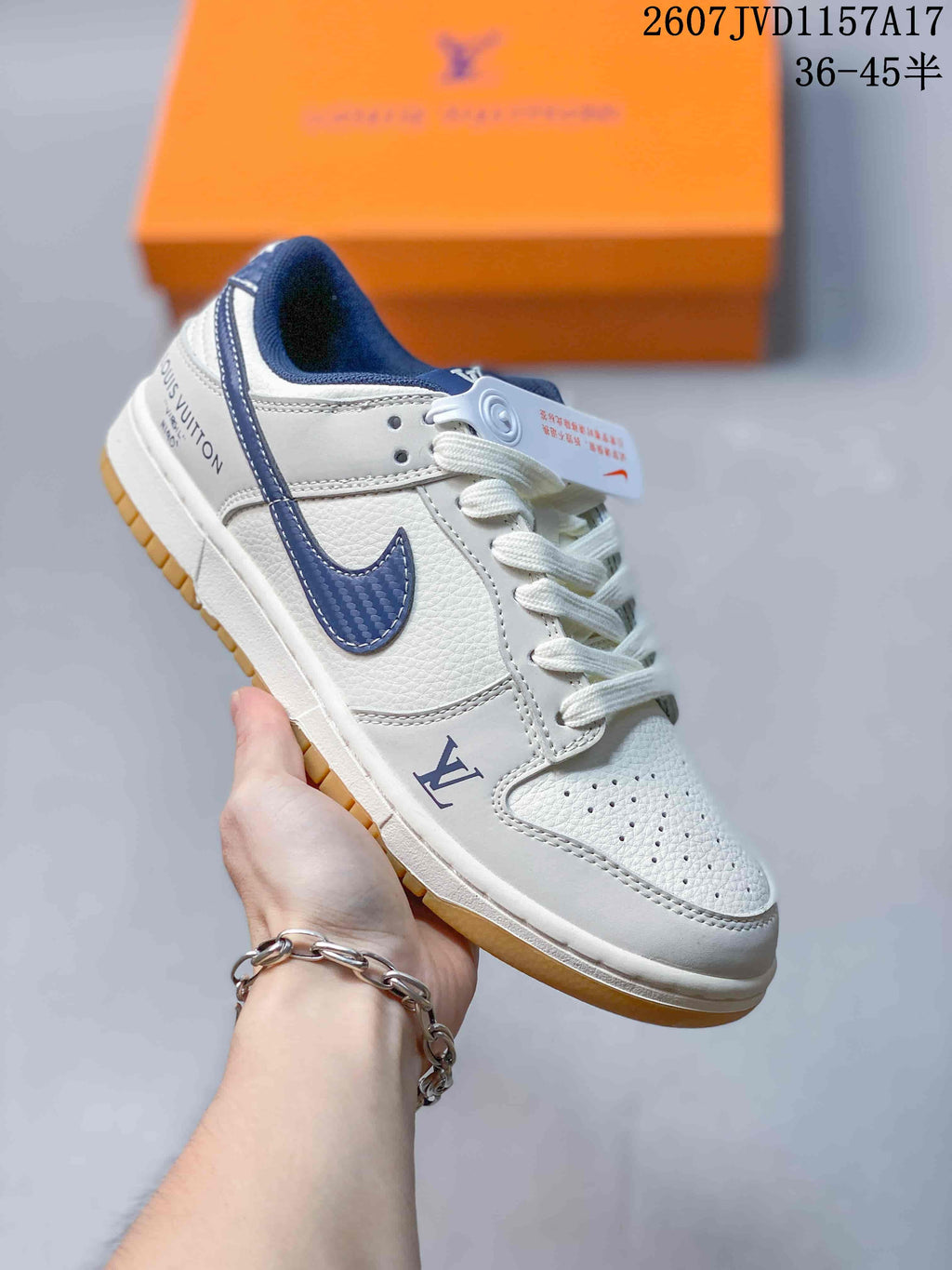 Angled side view of the white and navy sneaker showing the Louis Vuitton detail near the forefoot, navy Swoosh, and gum outsole.