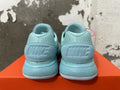 Rear view of mint green Nike sneakers with textured heel panels and ridged soles