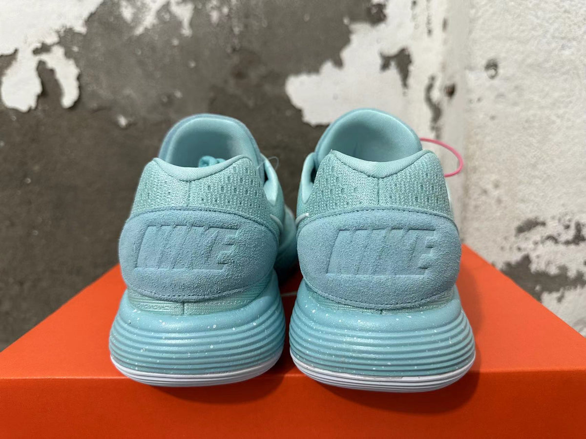 Rear view of mint green Nike sneakers with textured heel panels and ridged soles